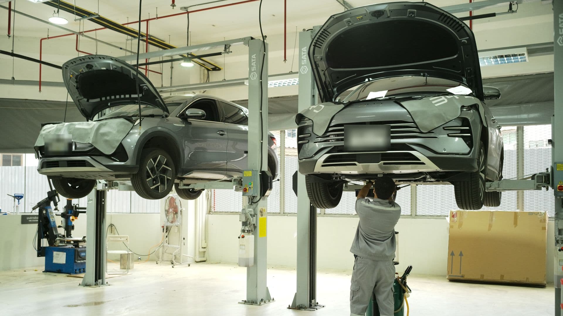 ช่างศูนย์บริการ BYD Hi-Class ตรวจเช็กใต้ท้องรถ BYD บนลิฟต์ยก